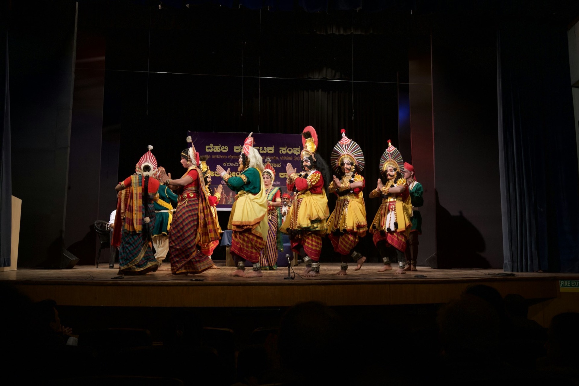 A costumed group performing on an auditorium stage