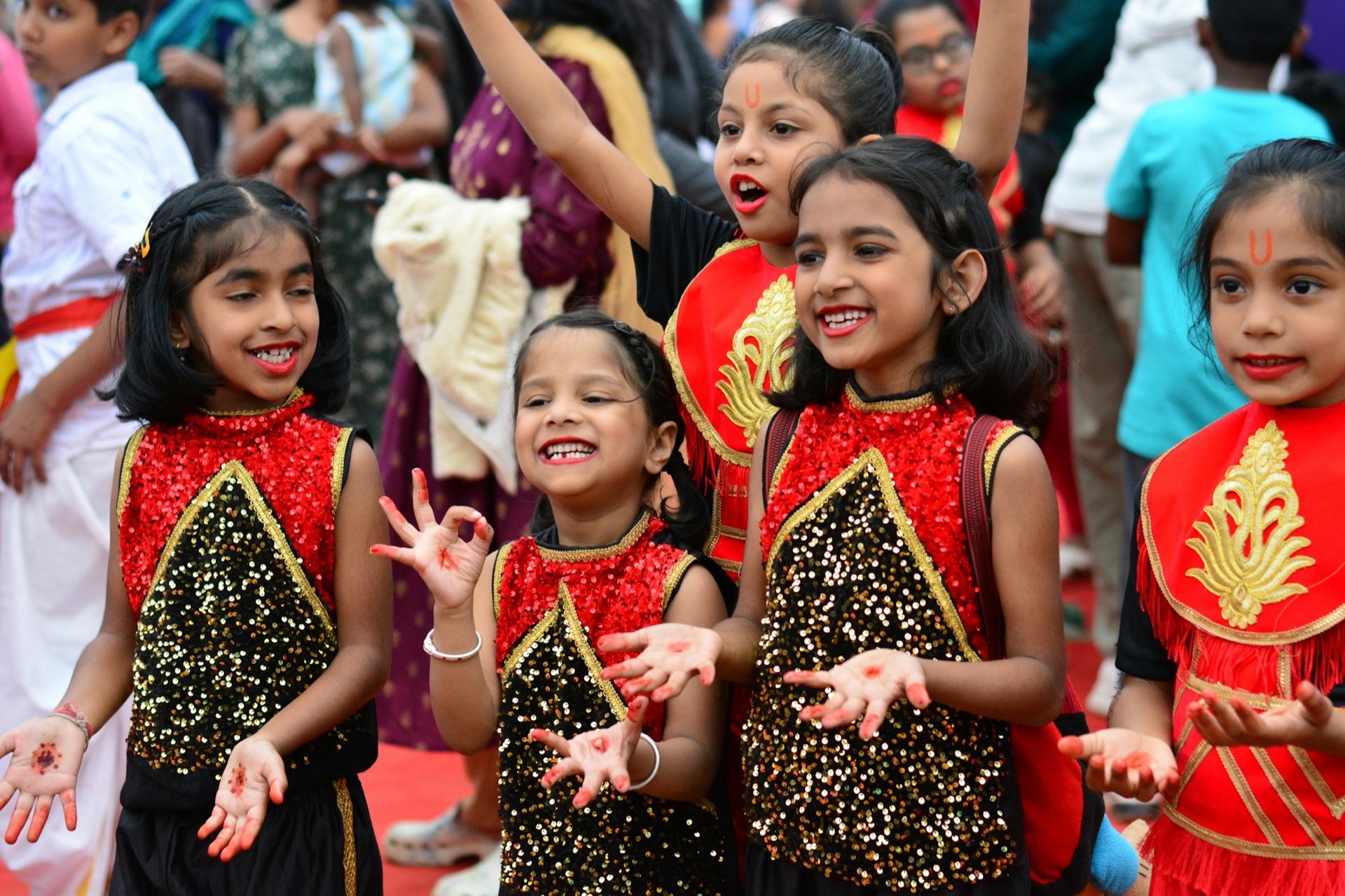 Girls in matching red-and-black sequinned dance costumes at a school function