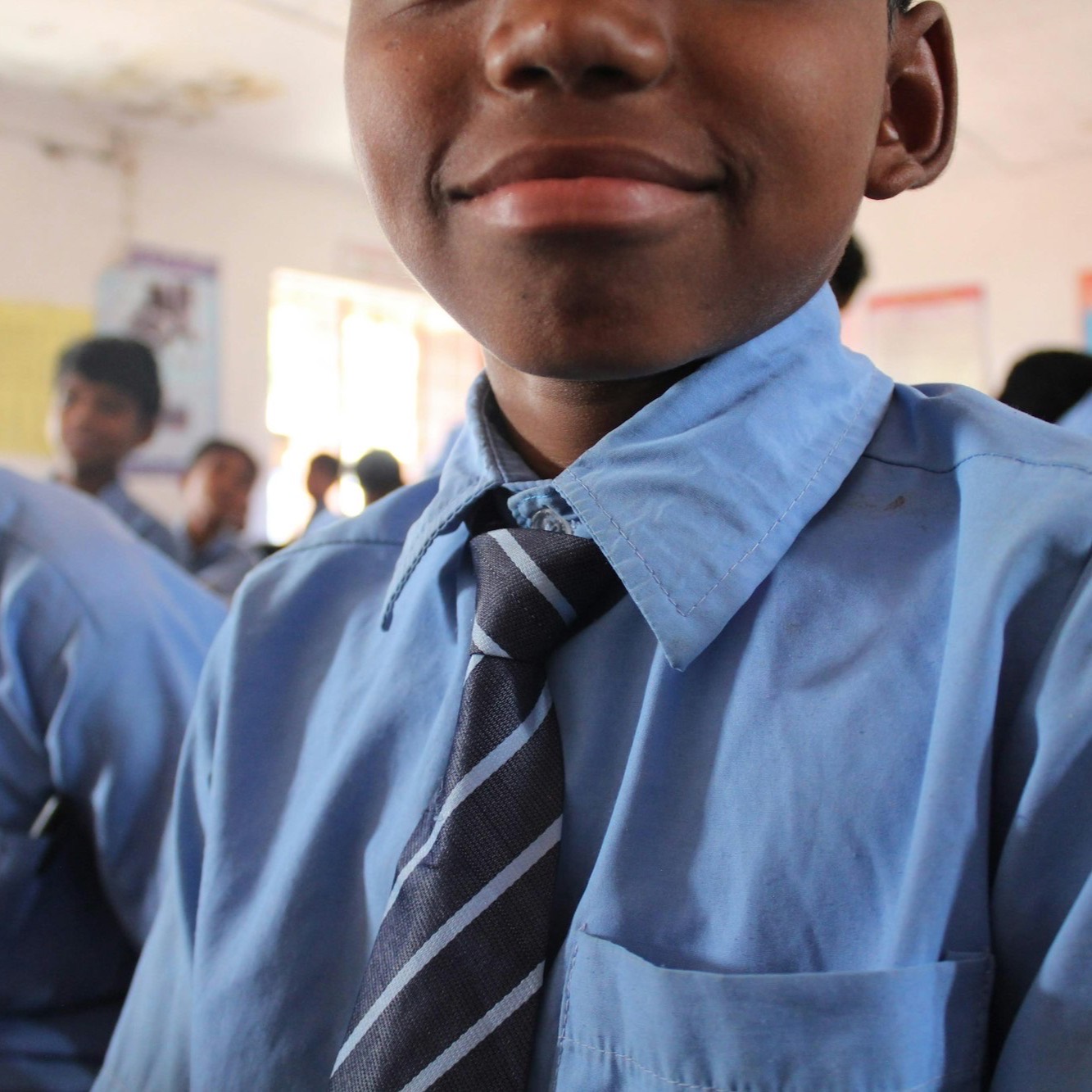 Close-up of a light-blue uniform shirt and striped school tie